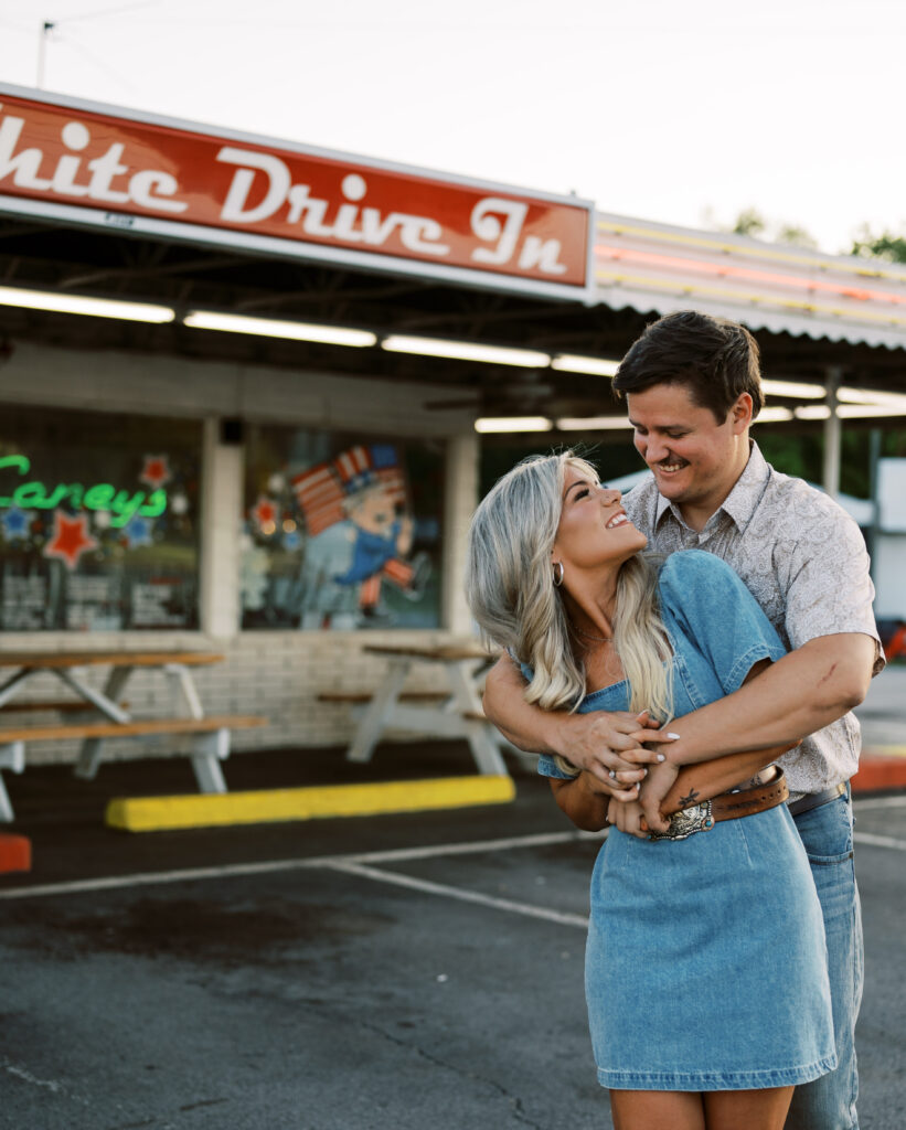 Engaged couple in front of drive in diner