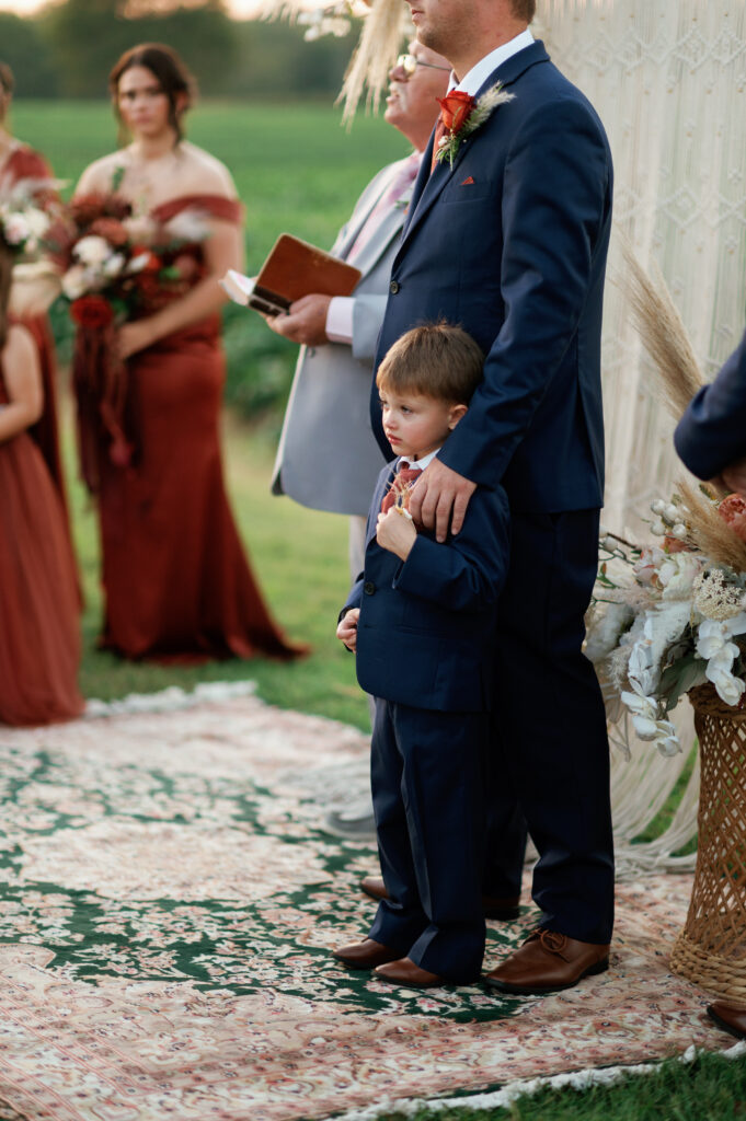 Groom awaits bride to walk down aisle with ringbearers. 