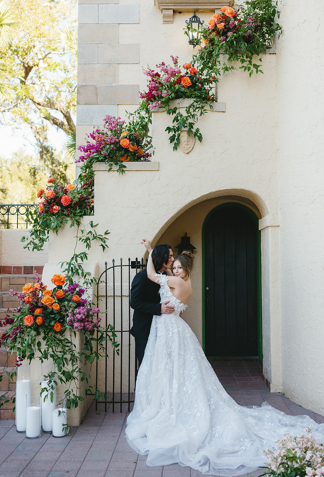 A bride smiles over her shoulder while hugging her groom under an arch at their Powel Crosley Estate Wedding