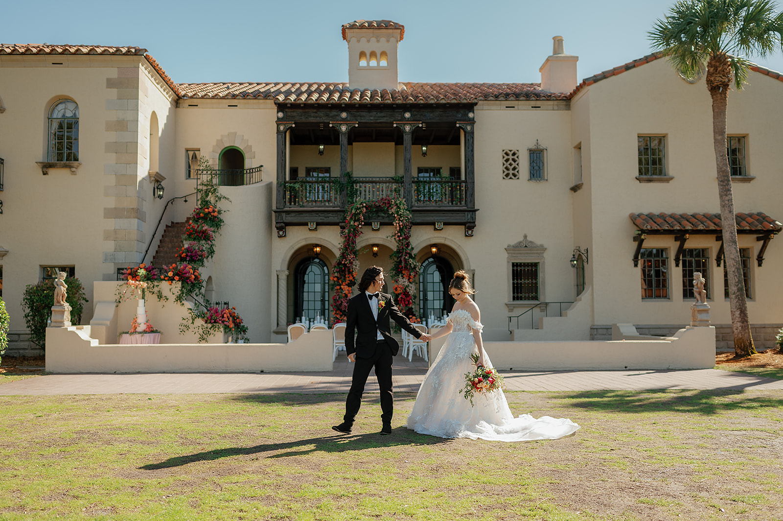 Newlyweds hold hands while walking across the lawn at their Powel Crosley Estate Wedding