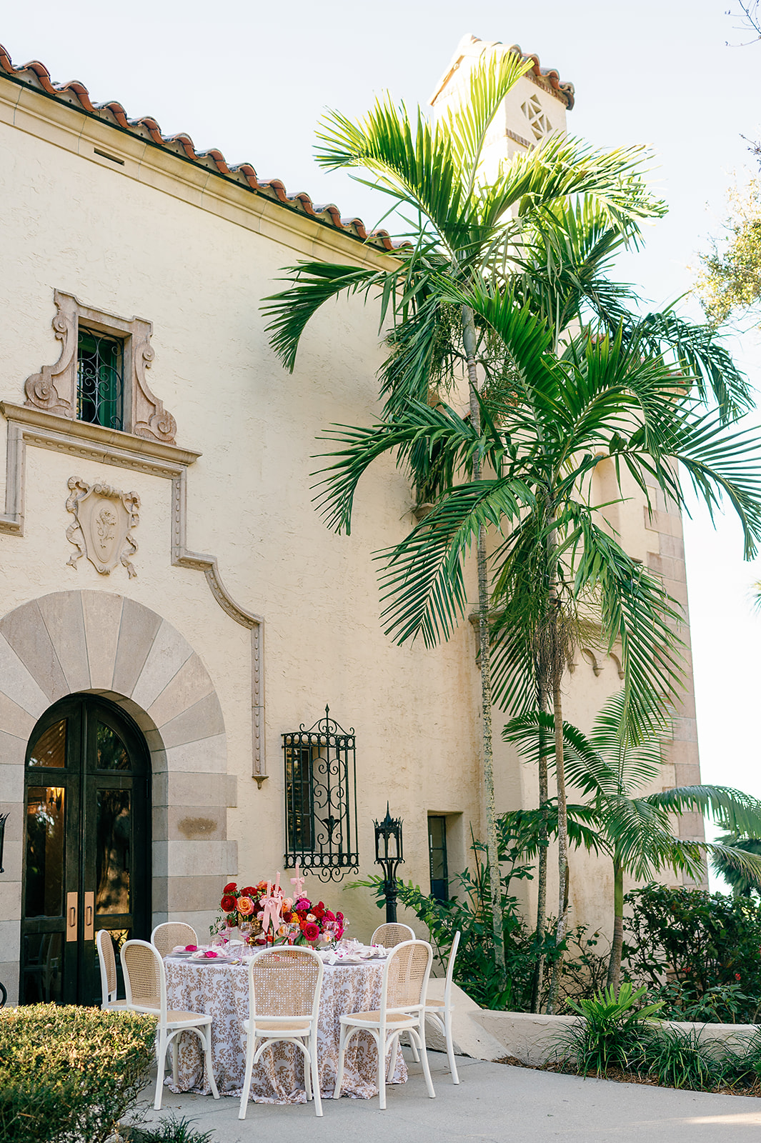 Details of a wedding reception table set up under palm trees on a spanish style estate