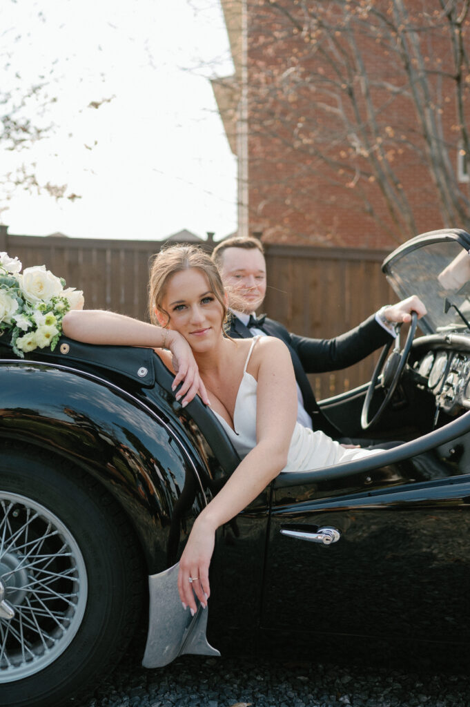 Couple posing with vintage car at Estelle Nashville venue. 