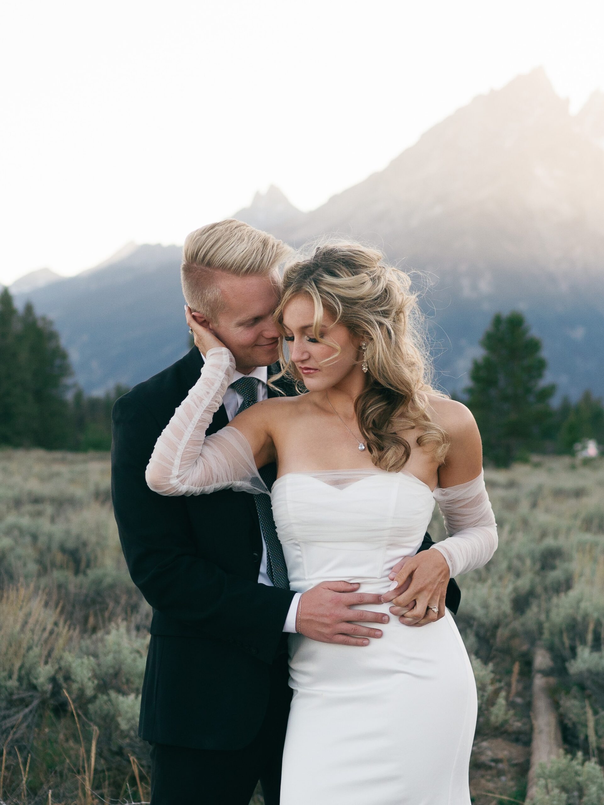 Newlyweds share an intimate snuggle in a remote trail at one of the Jackson Hole Wedding venues