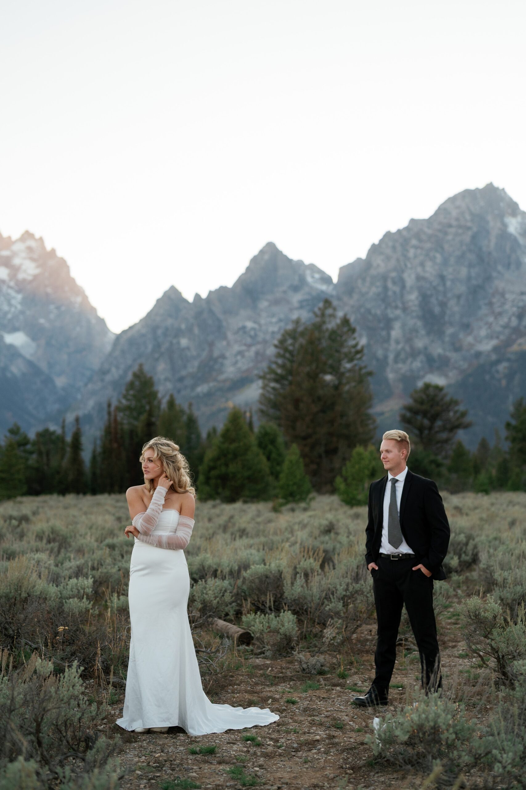 A groom walks up to his bride on a mountain trail at one of the Jackson Hole Wedding venues