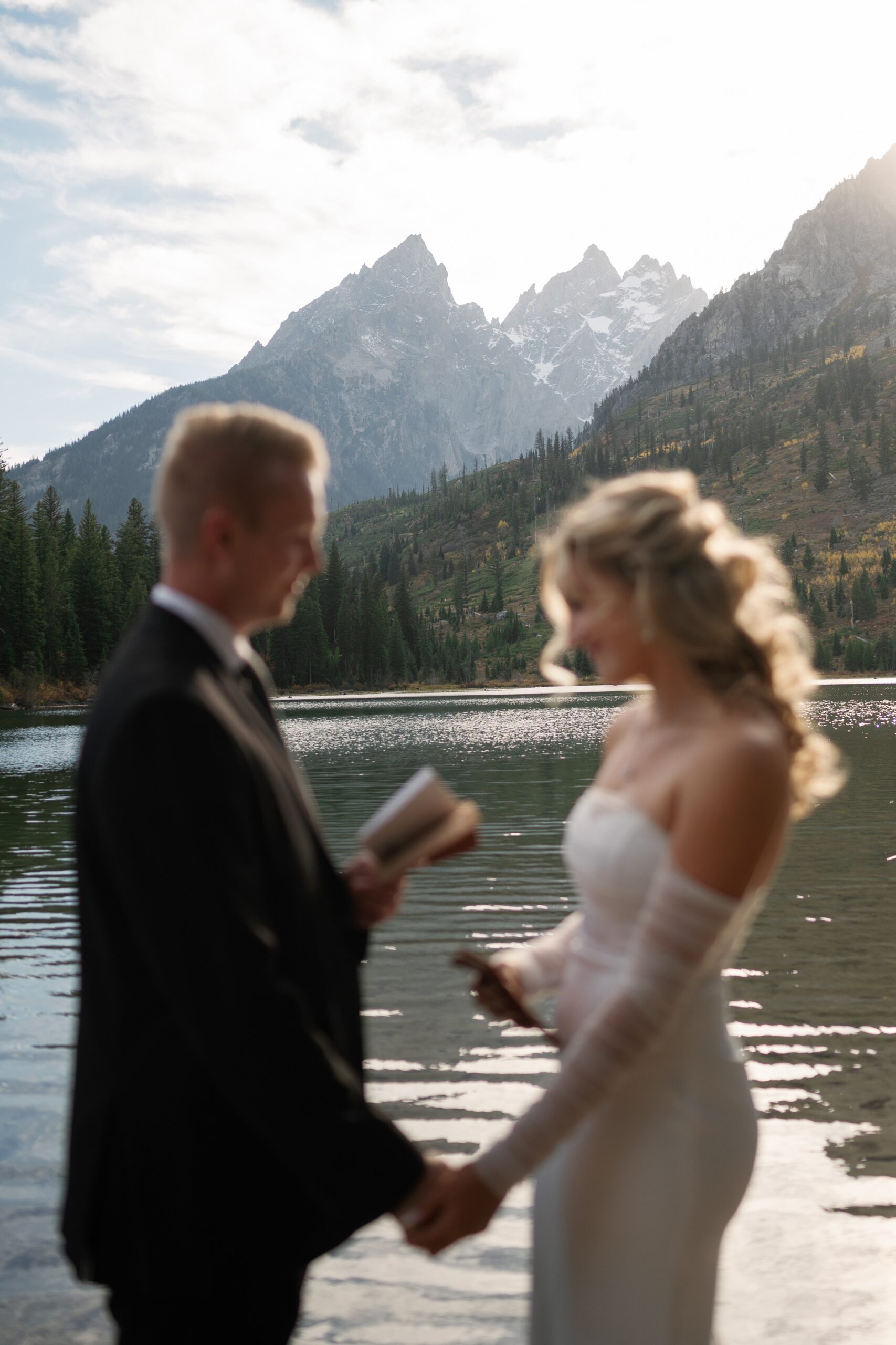 Newlyweds exchange vows by a lake in the mountains at one of the Jackson Hole Wedding venues